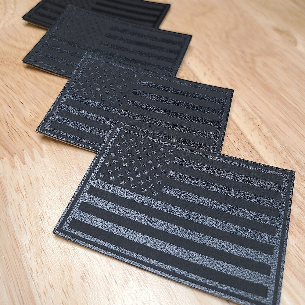 Single Track Hats black leatherette patch with embossed USA flag design. Subtle patriotic accessory.